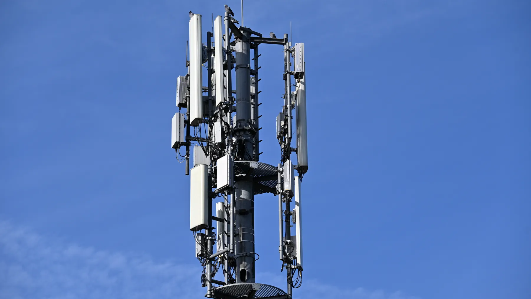 Moderner Mobilfunkmast mit Antennen vor klarem Himmel, redaktionelles Symbolbild zu A1 Telekom Austria und dem Netzausbau.