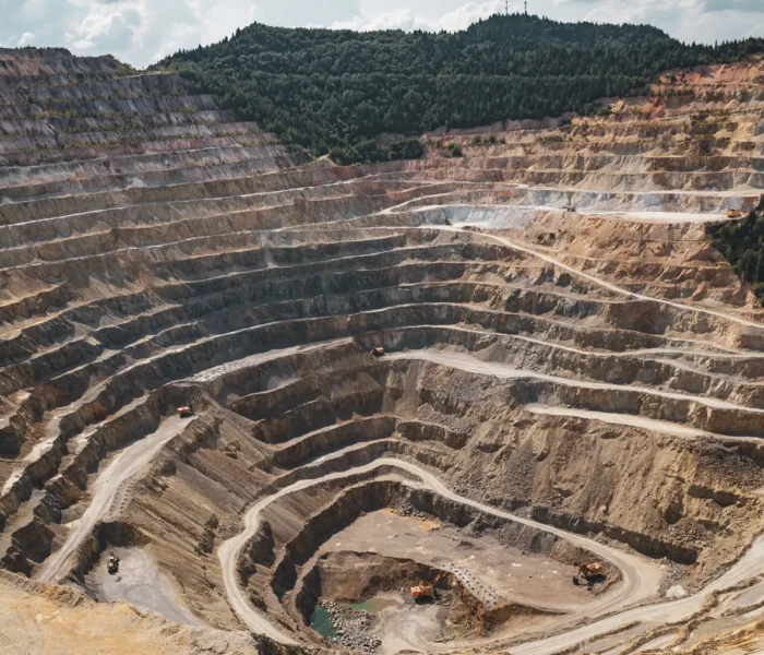 Luftaufnahme eines weitläufigen Tagebaus mit terrassierten Grubenwänden als Symbolbild für die Kupferförderung von BHP.