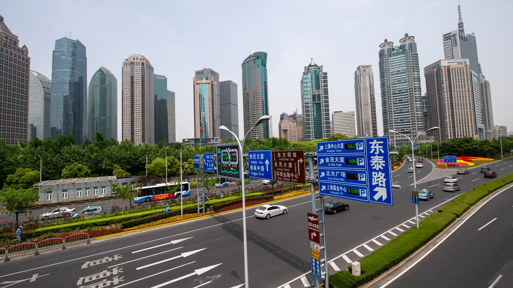 Breite Shanghaier Stadtautobahn mit Fahrzeugverkehr vor moderner Skyline als Sinnbild des chinesischen Automarkts.