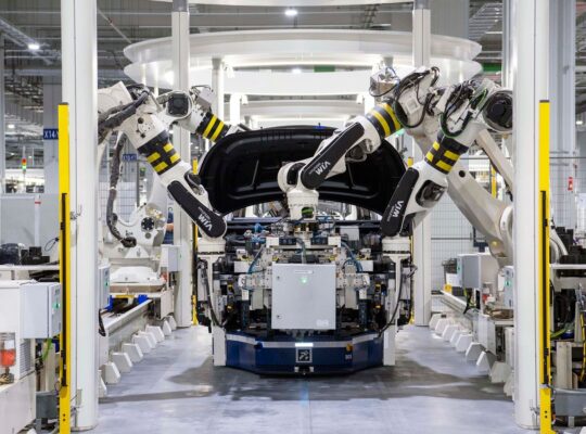 Roboter in einer modernen Autofabrik als Symbol für EV-Transformation, Investitionen und Cashflow der deutschen Autoindustrie.