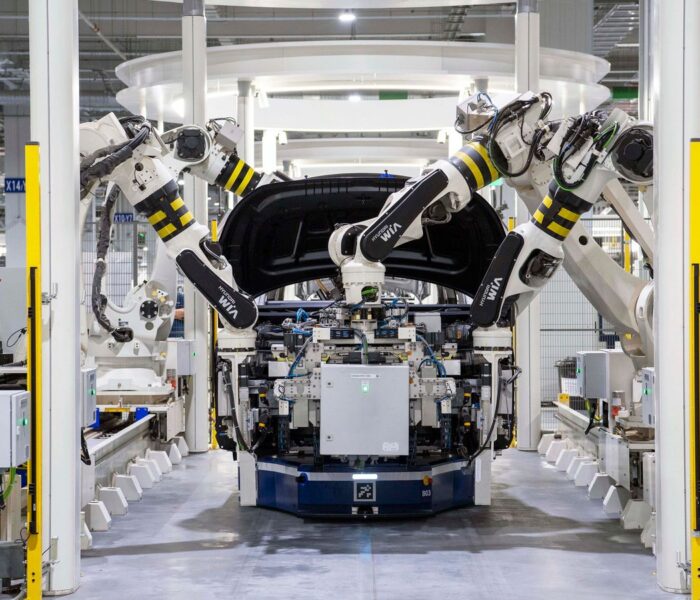 Roboter in einer modernen Autofabrik als Symbol für EV-Transformation, Investitionen und Cashflow der deutschen Autoindustrie.