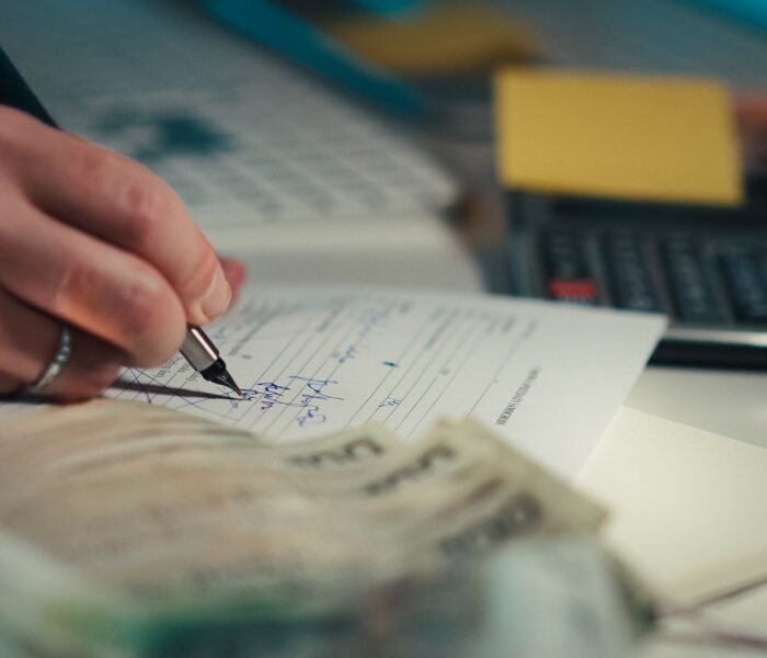 Dunkler Finanzarbeitsplatz mit Rechner und Finanzdokumenten als Symbol für EBITDA, Margen und Unternehmensanalyse.