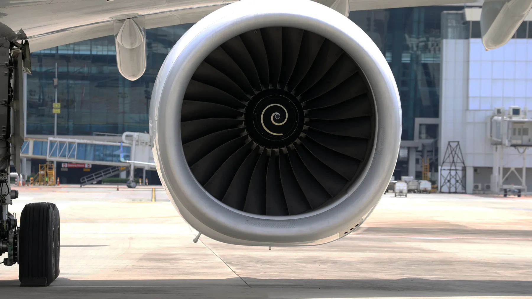 Großes ziviles Flugzeugtriebwerk an einem Verkehrsflugzeug auf dem Rollfeld, Symbolbild für GE Aerospace und Triebwerkswartung.