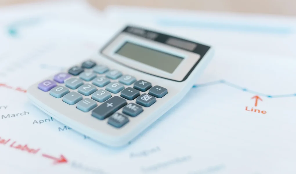 Analystische Finanzdokumente mit Rechner und Grafiken als Titelbild zur Sum-of-the-Parts-Bewertung einer Holding.