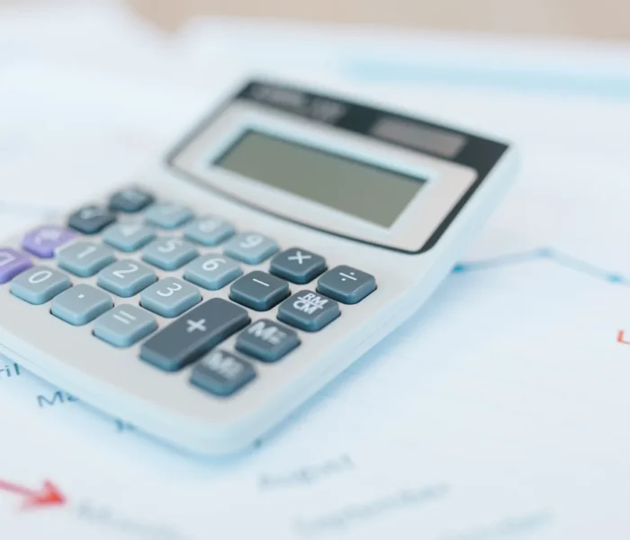 Analystische Finanzdokumente mit Rechner und Grafiken als Titelbild zur Sum-of-the-Parts-Bewertung einer Holding.