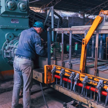 Industriebeschäftigter arbeitet an Maschinen in einer Fabrik als Symbolbild für die deutsche Wirtschaft und Industrieaufträge.