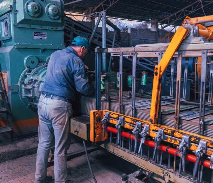 Industriebeschäftigter arbeitet an Maschinen in einer Fabrik als Symbolbild für die deutsche Wirtschaft und Industrieaufträge.