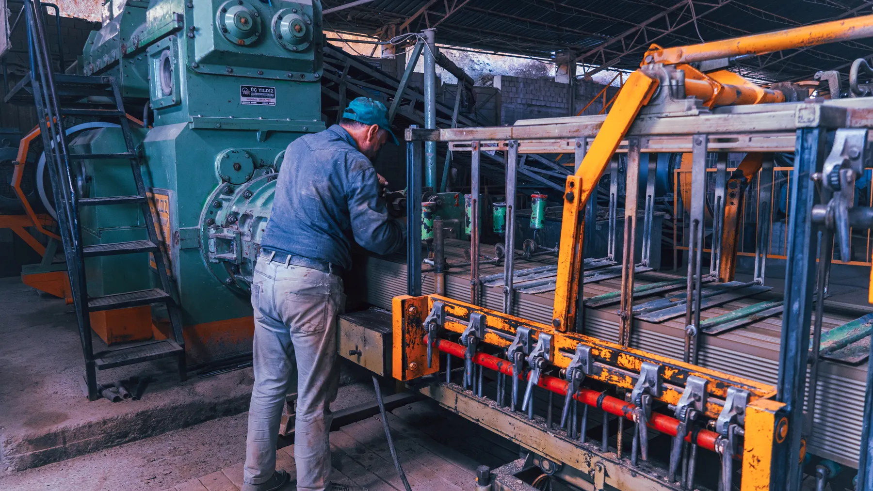 Industriebeschäftigter arbeitet an Maschinen in einer Fabrik als Symbolbild für die deutsche Wirtschaft und Industrieaufträge.