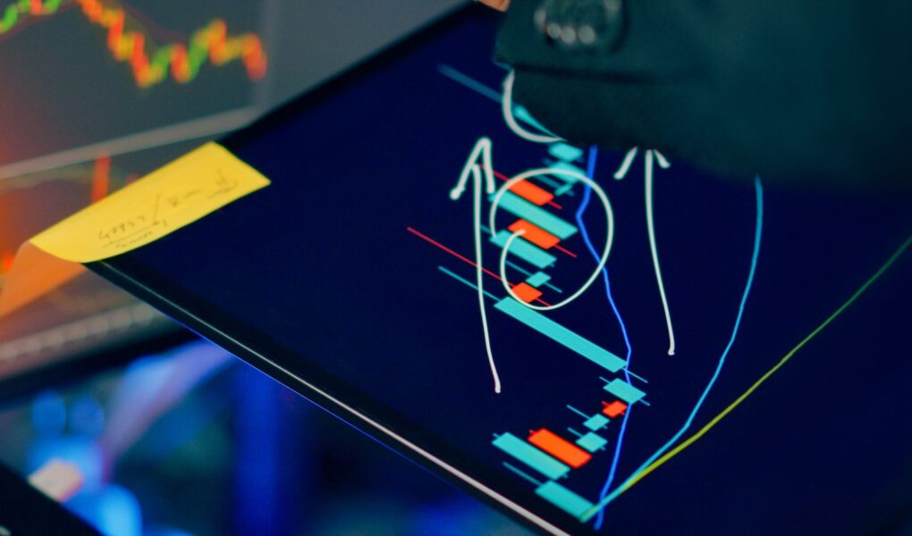 Analyst prüft Finanzcharts auf mehreren Bildschirmen als Symbol für Korrelation und Diversifikation.