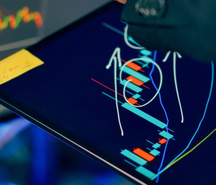 Analyst prüft Finanzcharts auf mehreren Bildschirmen als Symbol für Korrelation und Diversifikation.