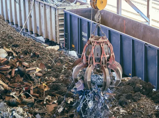 Greifkran hebt Metallschrott in einer großen industriellen Recyclinganlage als Titelbild für die Analyse europäischer Metallrecycler.