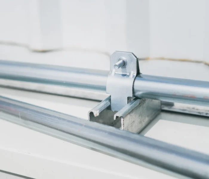 Detailaufnahme einer industriellen Rohrverbindung mit Metallschelle, als Motiv für die NewNORMA-Strategie und Verbindungstechnik.