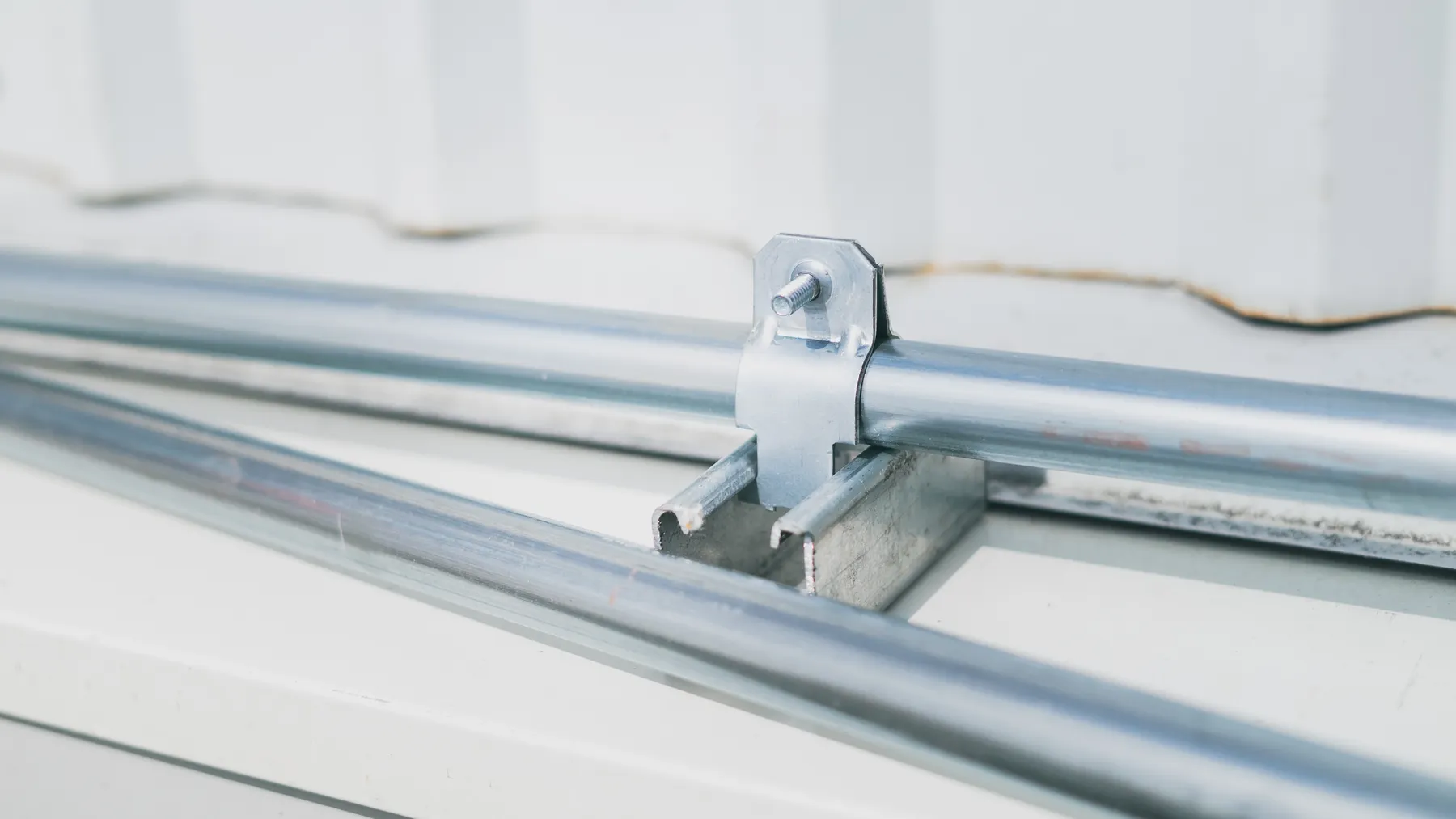 Detailaufnahme einer industriellen Rohrverbindung mit Metallschelle, als Motiv für die NewNORMA-Strategie und Verbindungstechnik.