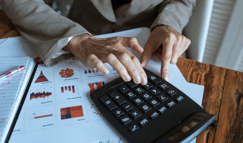 Finanzanalyst berechnet Kennzahlen anhand von Charts und Tabellen als Symbol für PEG Ratio, KGV und Gewinnwachstum.