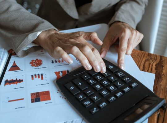 Finanzanalyst berechnet Kennzahlen anhand von Charts und Tabellen als Symbol für PEG Ratio, KGV und Gewinnwachstum.