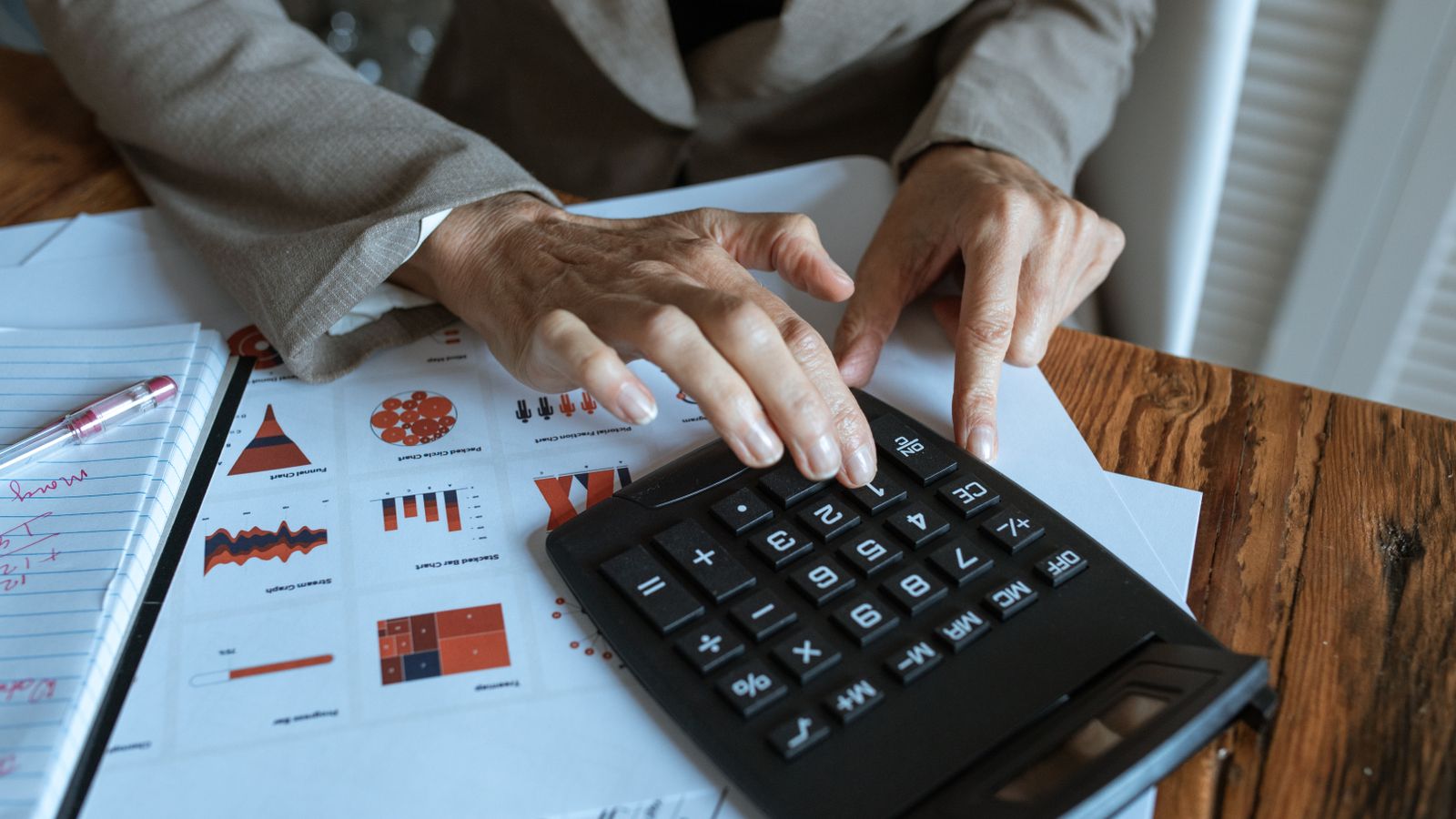 Finanzanalyst berechnet Kennzahlen anhand von Charts und Tabellen als Symbol für PEG Ratio, KGV und Gewinnwachstum.