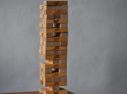 Holzklotzturm mit Lücken in seiner tragenden Struktur als Symbol für die Belastbarkeit eines Portfolios.