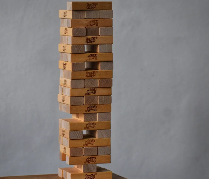 Holzklotzturm mit Lücken in seiner tragenden Struktur als Symbol für die Belastbarkeit eines Portfolios.