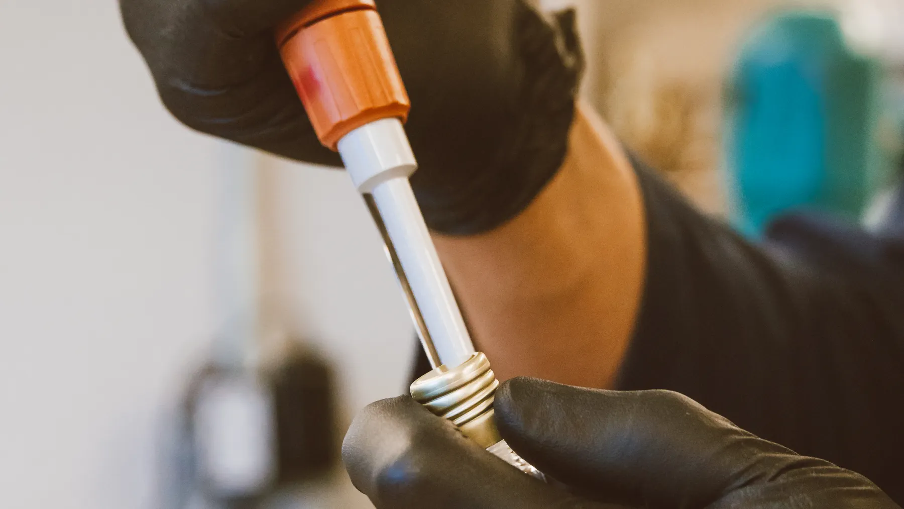 Laborfachkraft arbeitet mit Pipette und Probengefäß bei einer molekularbiologischen Untersuchung. Symbolbild zur QIAGEN-Übernahme.