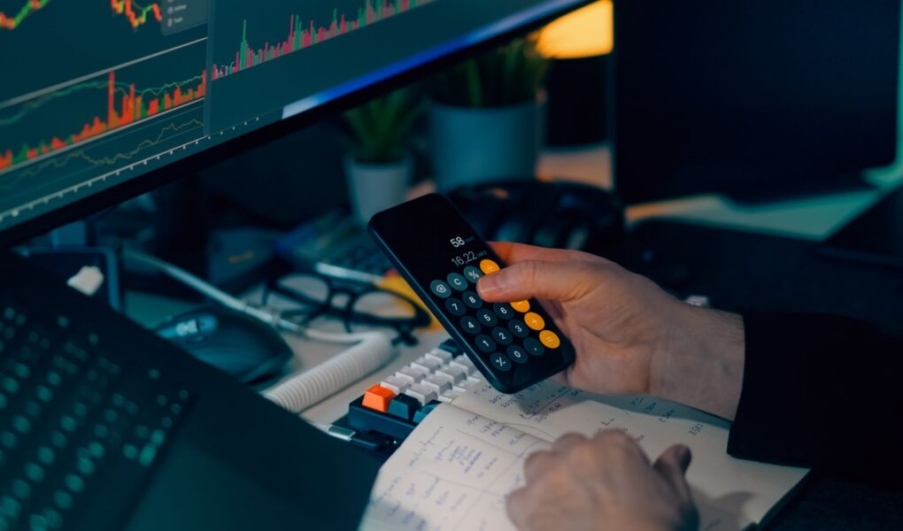 Finanzanalyst arbeitet mit Rechner und Marktcharts als Symbol für risikoadjustierte Rendite.
