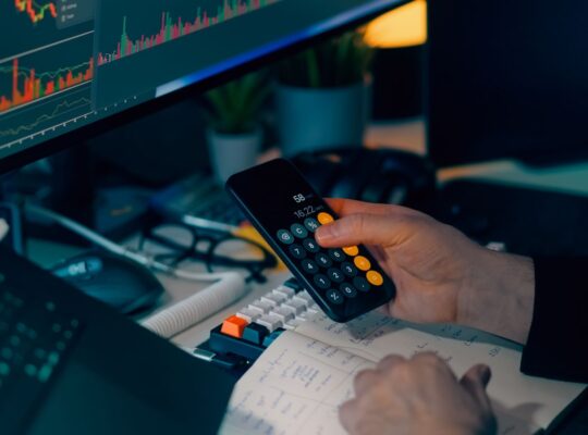 Finanzanalyst arbeitet mit Rechner und Marktcharts als Symbol für risikoadjustierte Rendite.