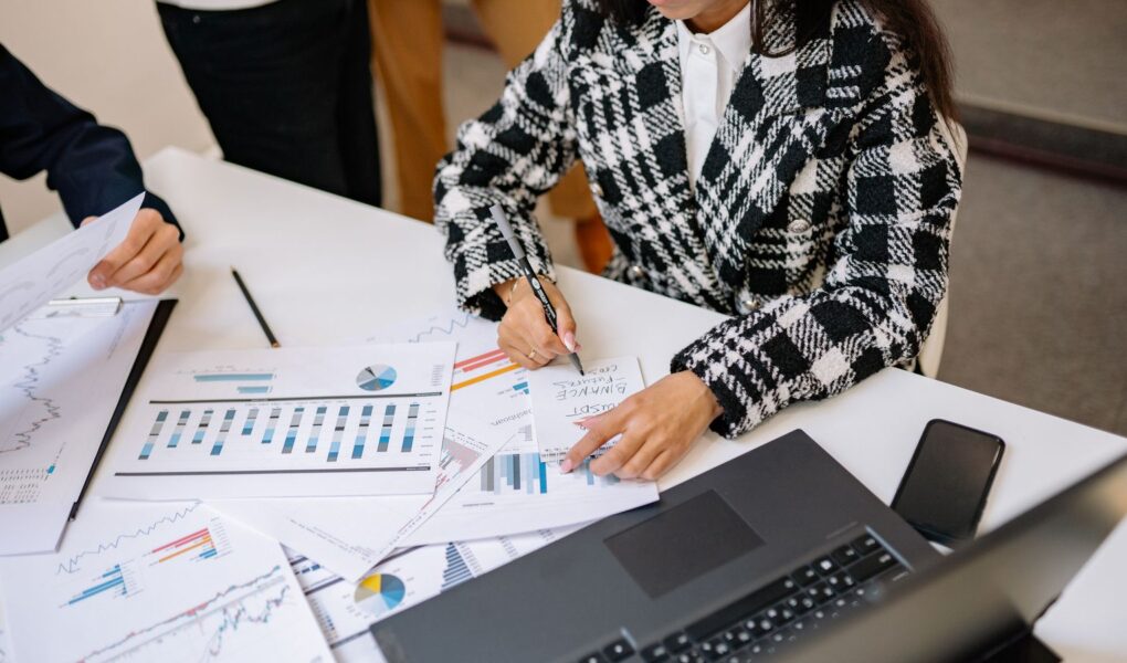 Analysten prüfen Finanzberichte und Charts als Symbol für die fundamentale Analyse von Small-Cap-Unternehmen.