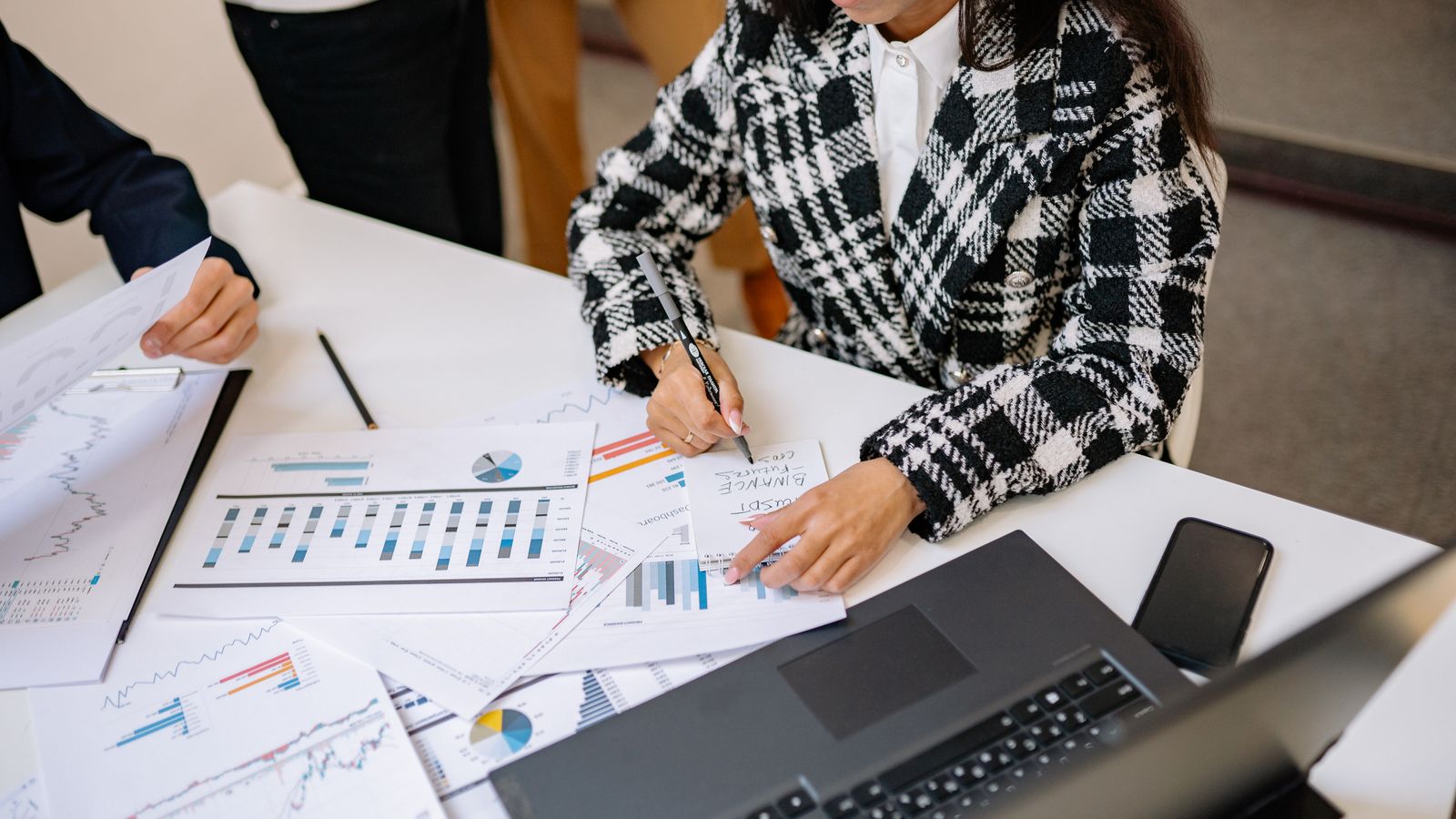 Analysten prüfen Finanzberichte und Charts als Symbol für die fundamentale Analyse von Small-Cap-Unternehmen.