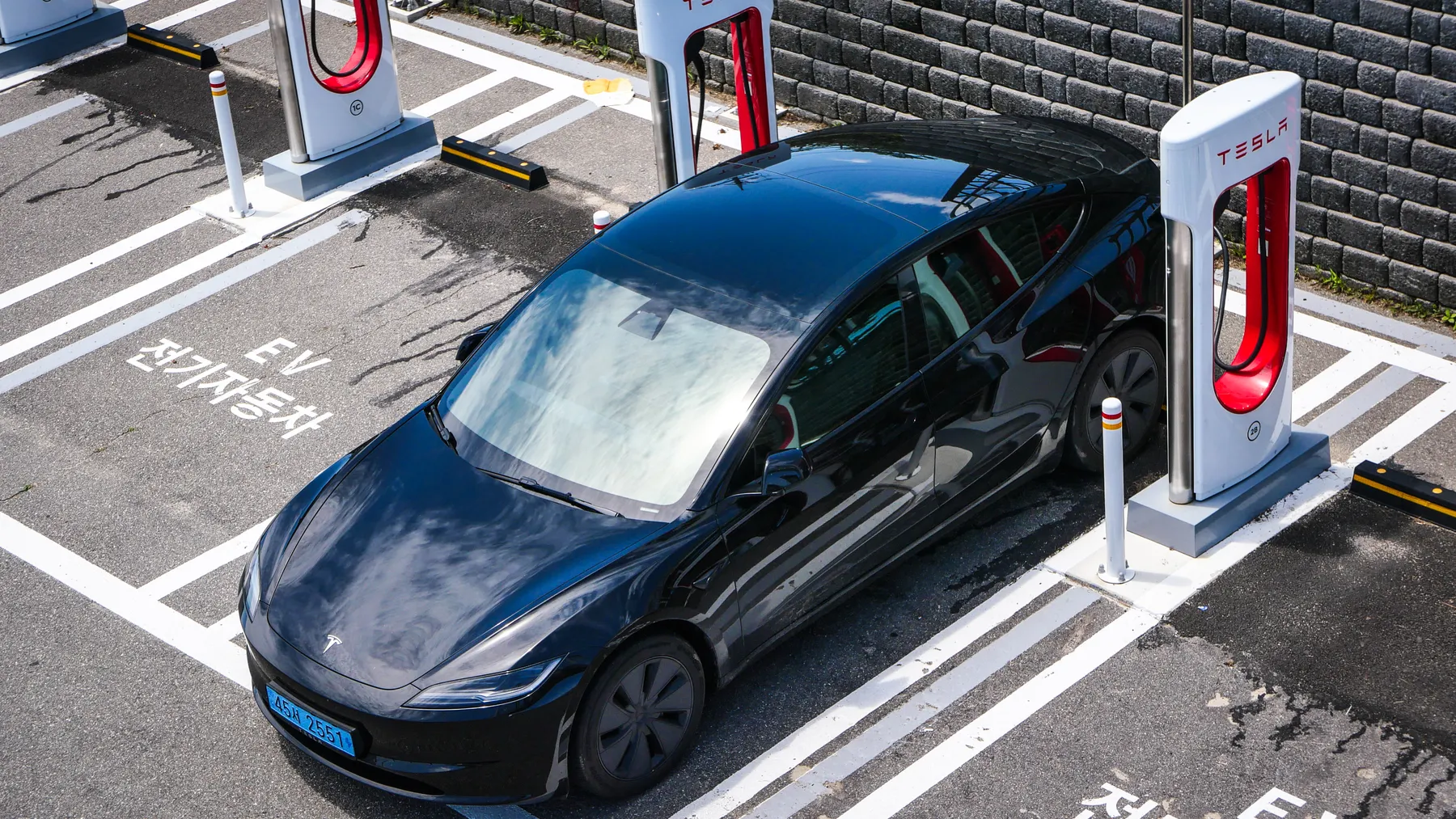 Schwarzer Tesla Model 3 an einer modernen Ladestation, textfreies Beitragsbild zur Tesla-Aktie und dem Q3-2026-Ergebnis.