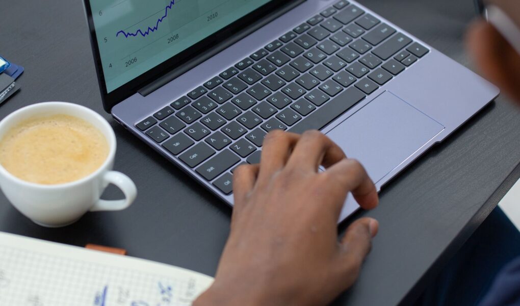 Professioneller Analyst prüft Finanzcharts am Laptop als Symbol für Umsatzwachstum je Aktie und Verwässerung.