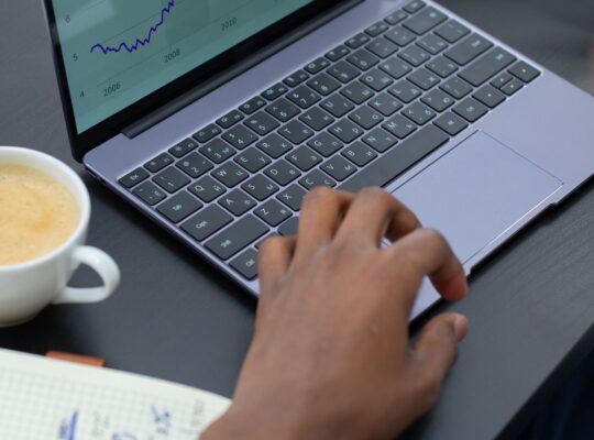 Professioneller Analyst prüft Finanzcharts am Laptop als Symbol für Umsatzwachstum je Aktie und Verwässerung.