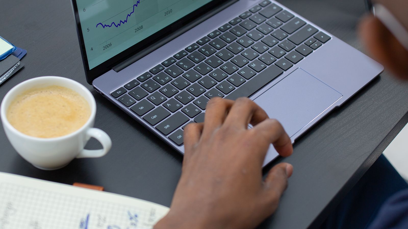 Professioneller Analyst prüft Finanzcharts am Laptop als Symbol für Umsatzwachstum je Aktie und Verwässerung.