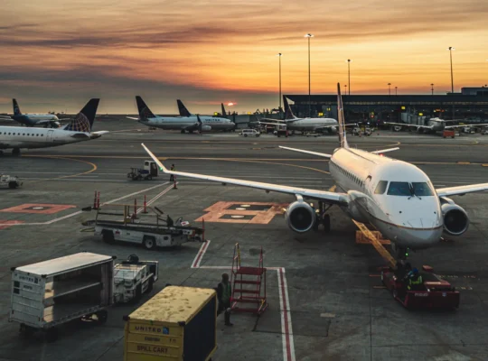 Passagierflugzeuge an einem beleuchteten Flughafen-Terminal im Abendlicht. Symbolbild zu VINCI Airports und den Q3-Passagierzahlen 2026.